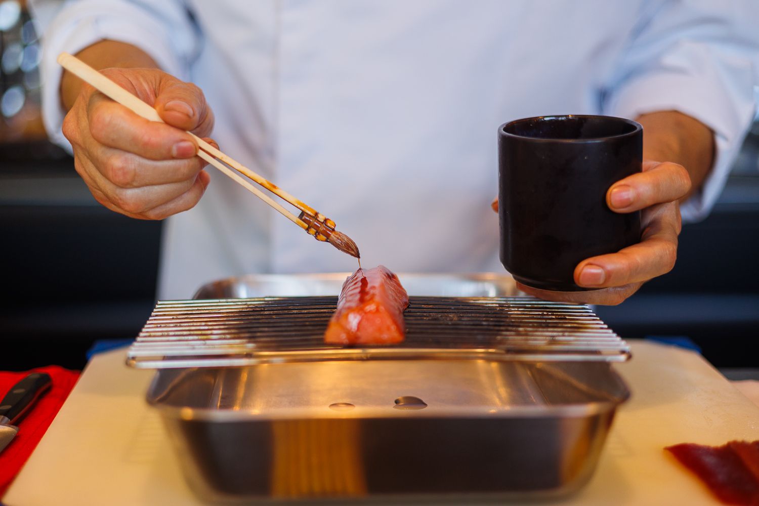 Detalle del sanluqueño pintando el salmón marinado.