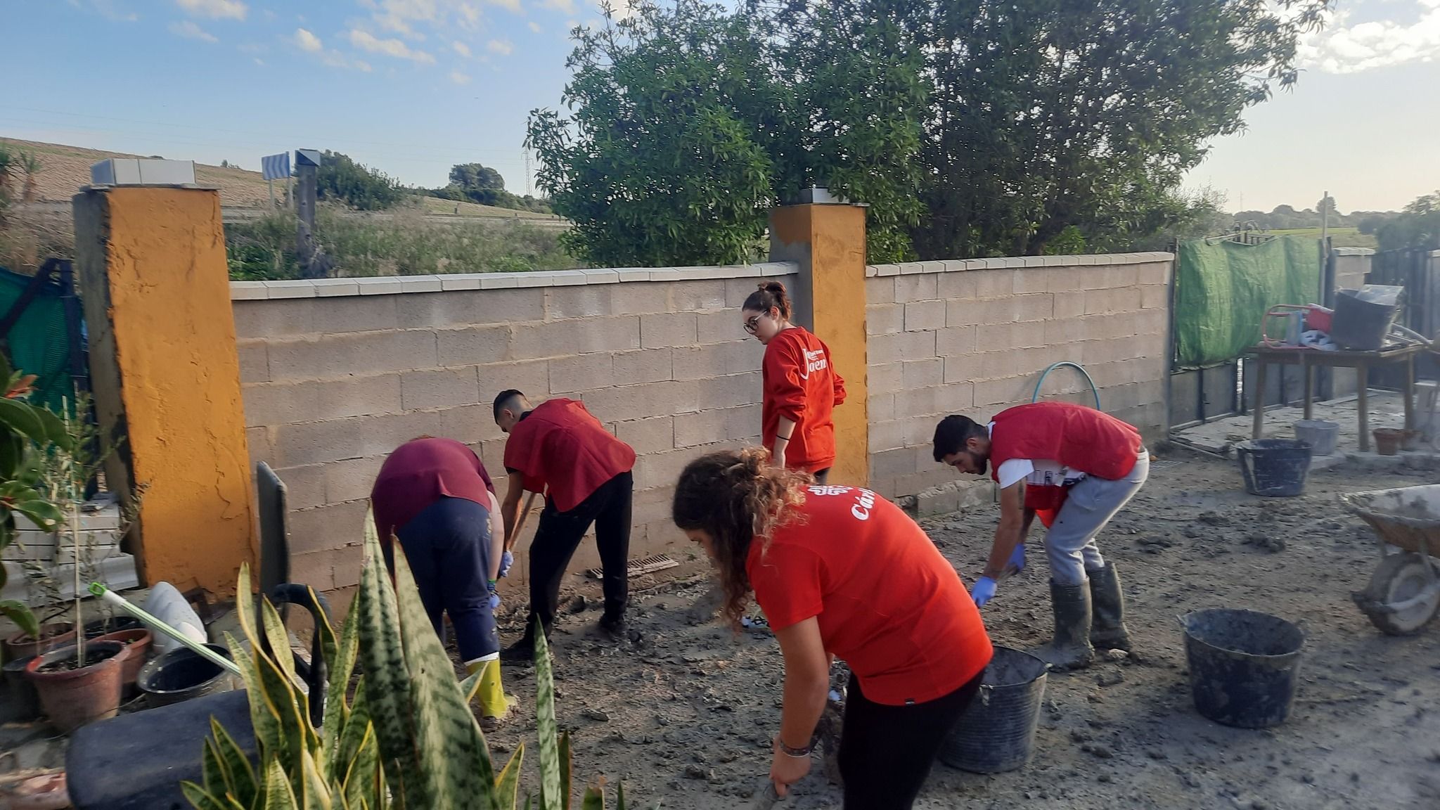 Unos jóvenes ayudan a una vecina afectada por las inundaciones de la DANA. Unos jóvenes ayudan a una vecina afectada por las inundaciones de la DANA.