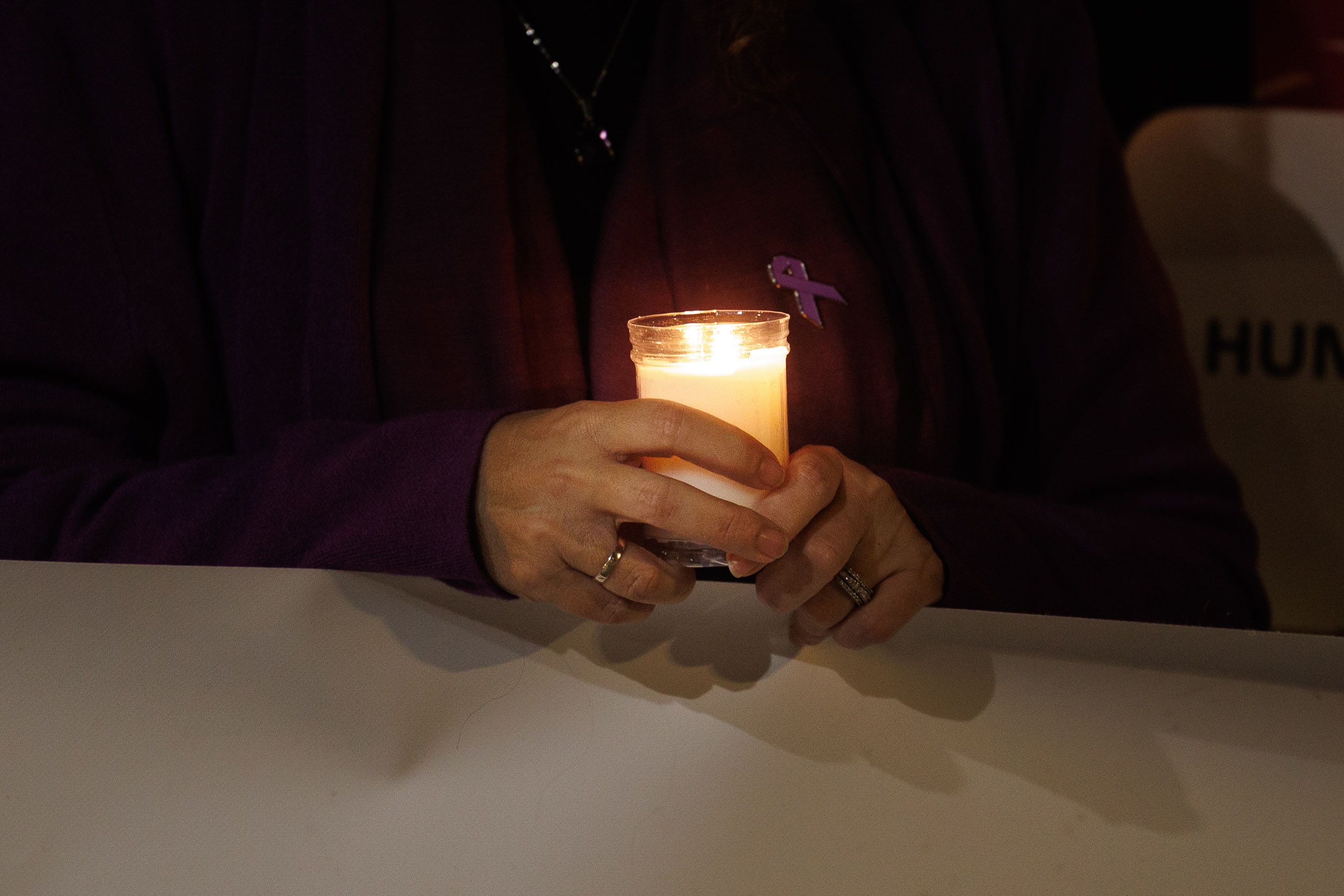 Una mujer sujeta una vela en una manifestación por el 25N.