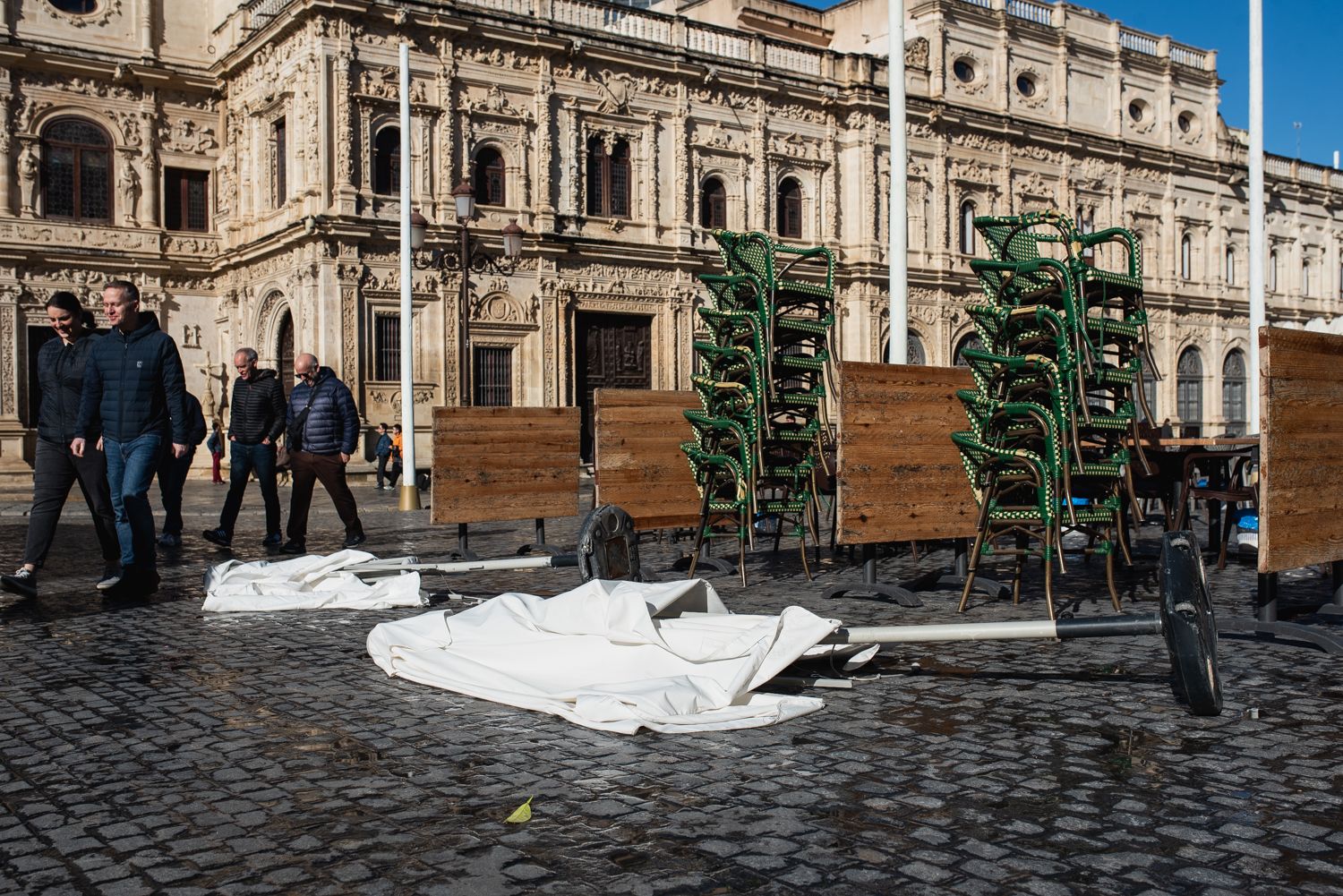 Imagen en Sevilla de sombrillas de veladores tumbadas por el viento, al paso de la borrasca 'Ivo' por Andalucía.