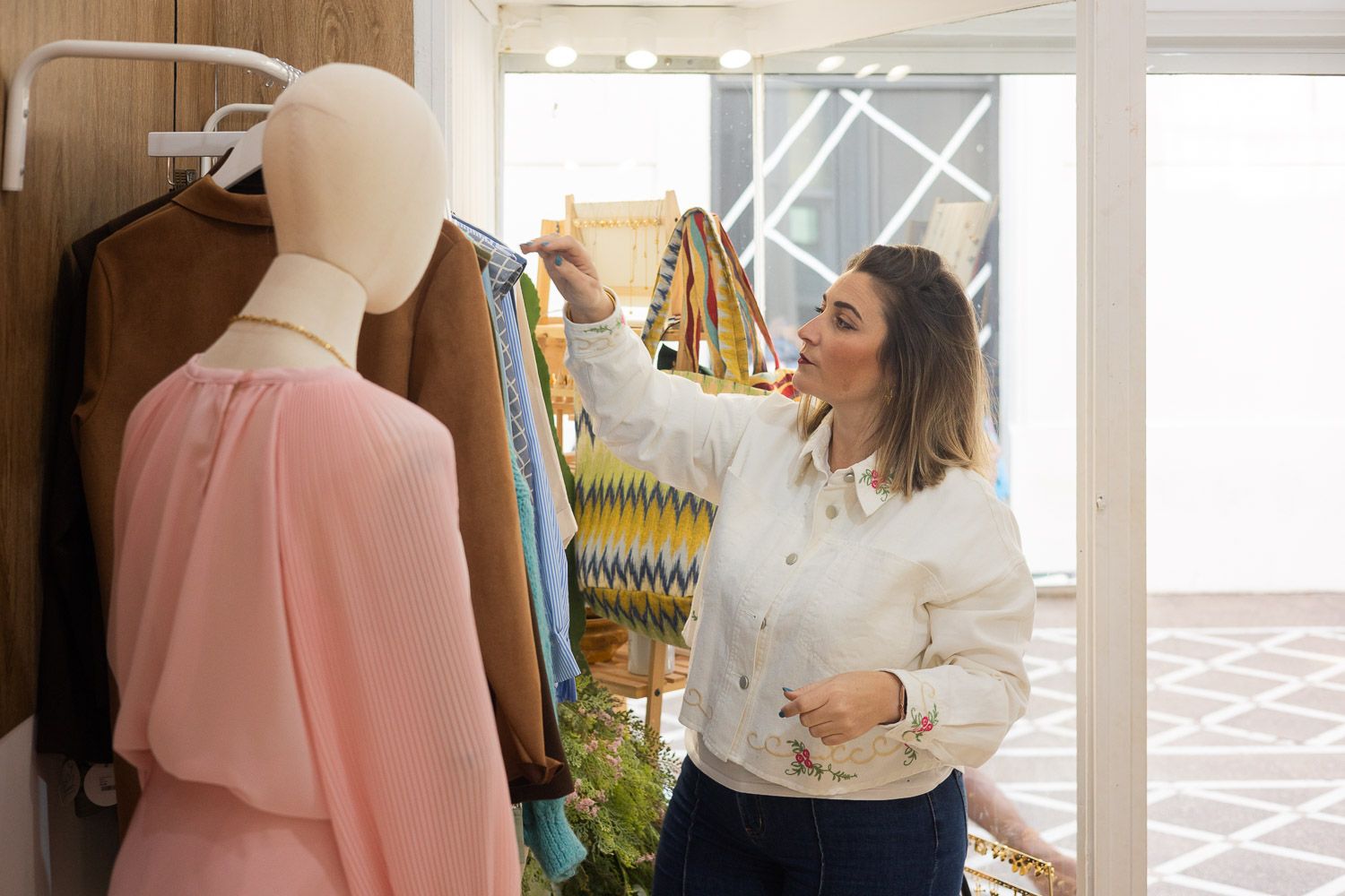 Una autónoma, revisando prendas de su tienda.
