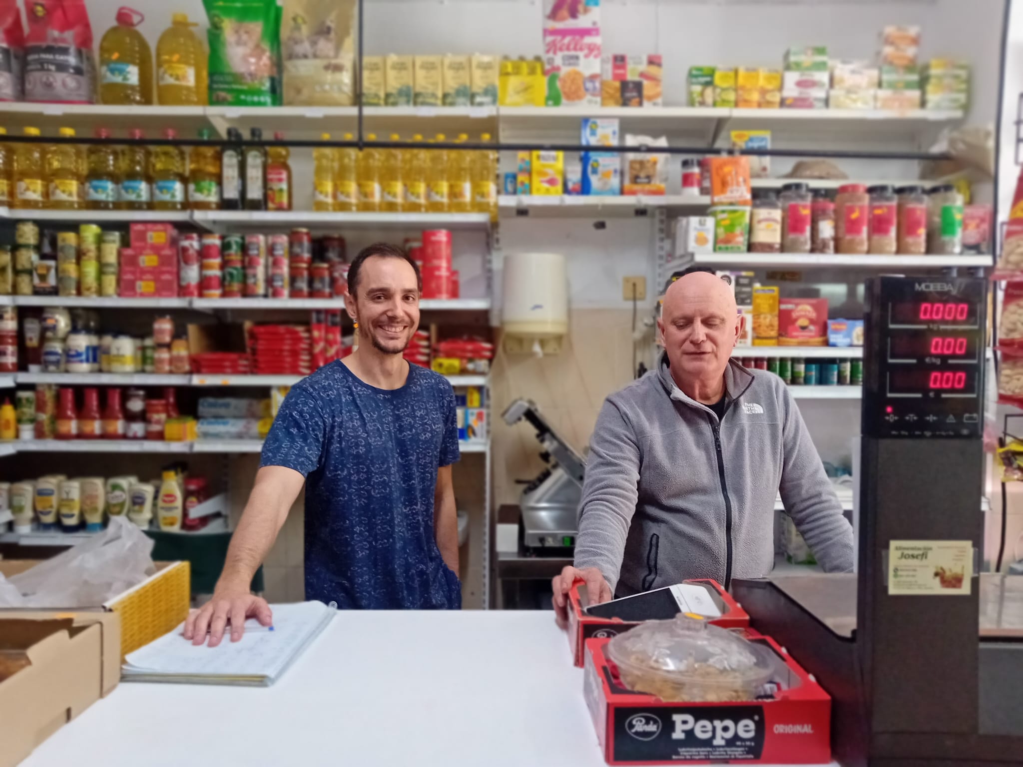 Fernando Begines, el tendero que sufrió el atraco en Los Palacios, con su hijo.
