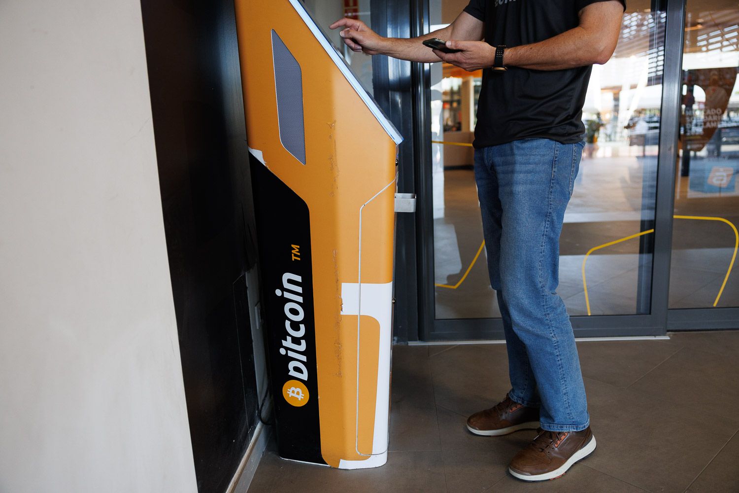 Una persona hace una gestión en un cajero de bitcoin.