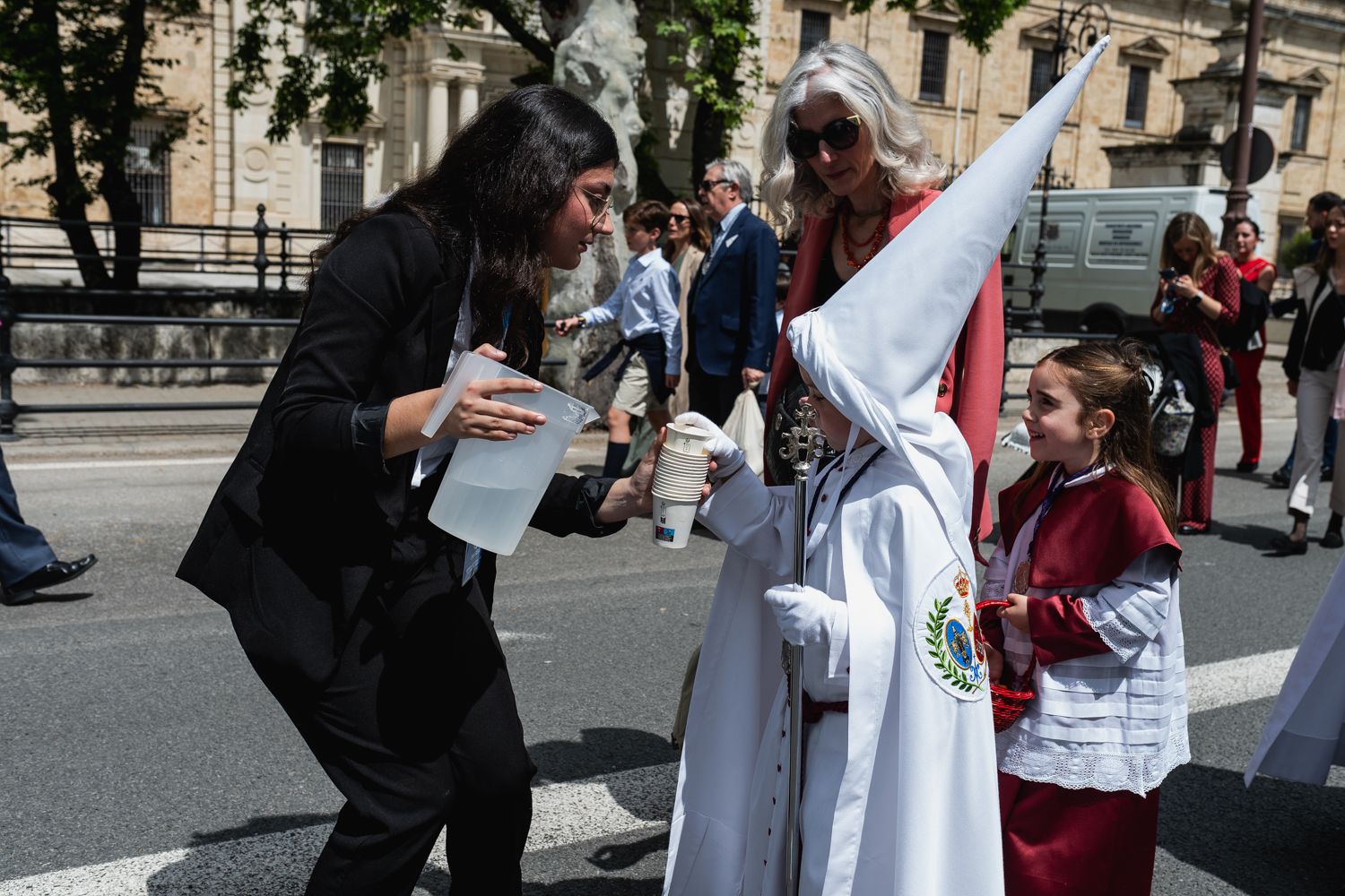 Un nazareno, con agua ofrecida por Emasesa, la empresa de agua de Sevilla.