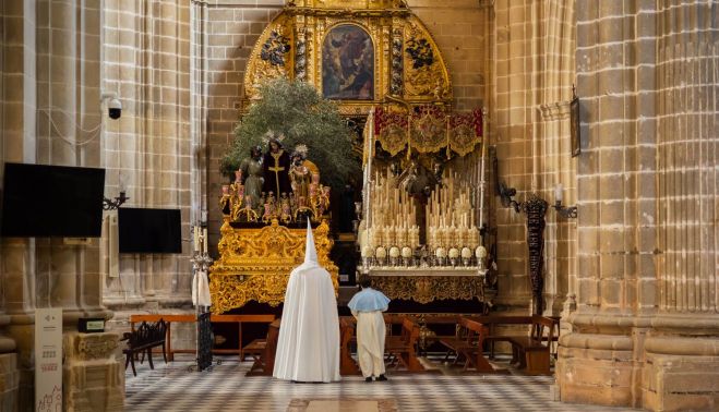 Un penitente y un monaguillo del Resucitado viendo el paso del Prendimiento