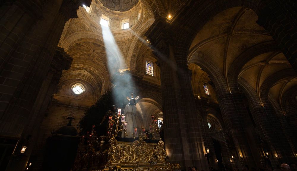 El paso del Prendimiento envuelto en la oscuridad, iluminado por un rayo de luz