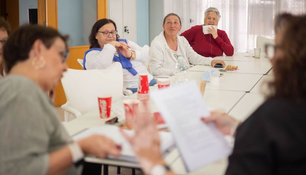 Las vecinas escuchan las lecturas seleccionadas.