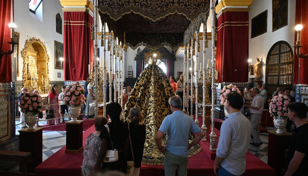 El numeroso público en el besamanos admirando a La Amargura, vista desde atrás, con el manto del Desconsuelo. 