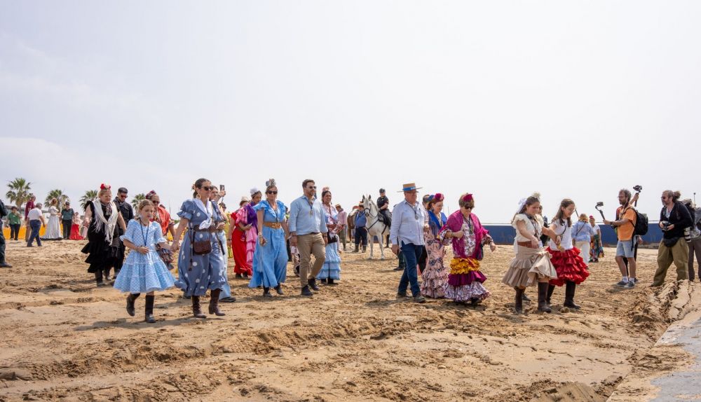 Peregrinos de Cádiz por la playa de Malandar tras cruzar el río. 