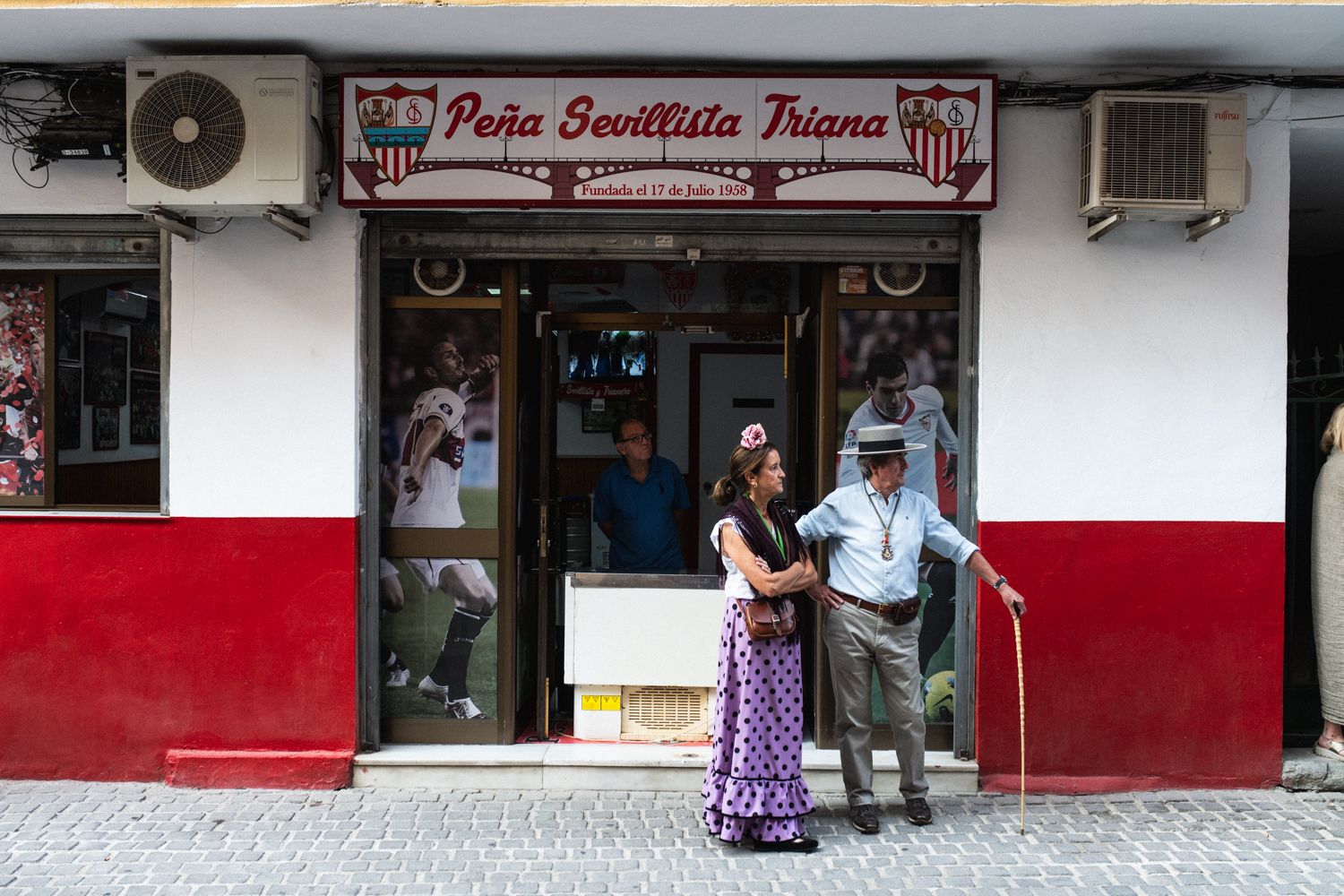 Peregrinos esperando al simpecado de Triana, en la Peña Sevillista Triana, en la calle Rodrigo de Triana.
