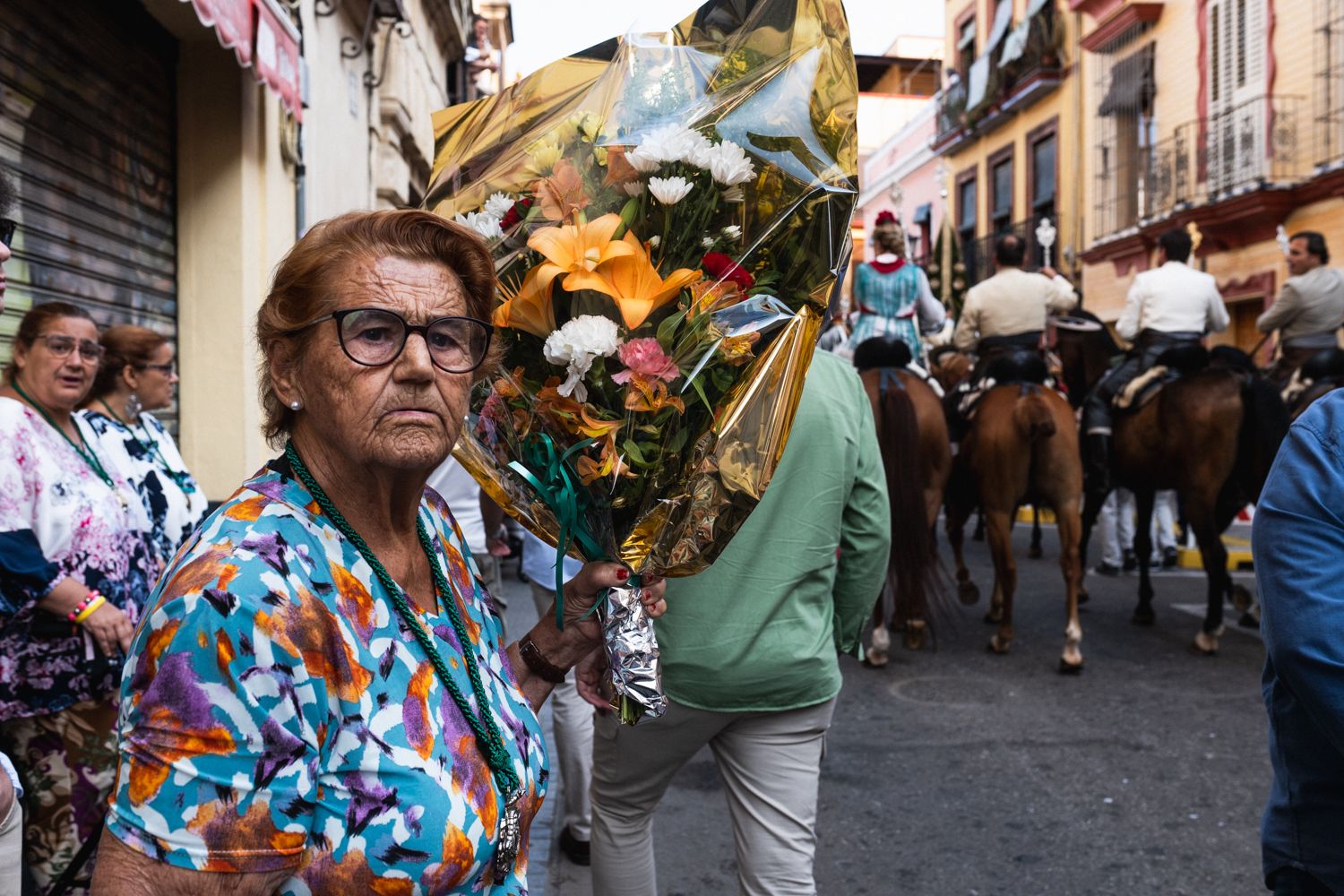 Una mujer, esperando para hacer una ofrenda de flores al simpecado de Triana.