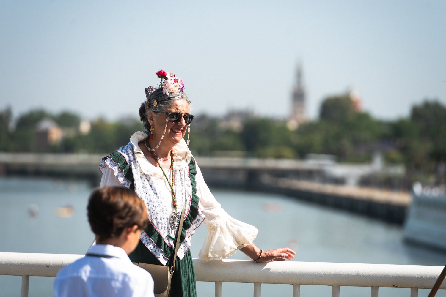 Una peregrina se hace una foto, con el río  y la Giralda de fondo.