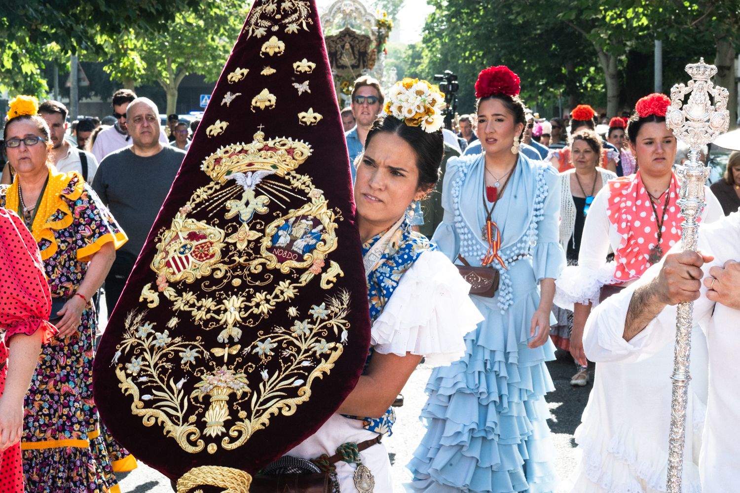 Una peregrina portando el nuevo estandarte de la Hermandad Sevilla Sur.