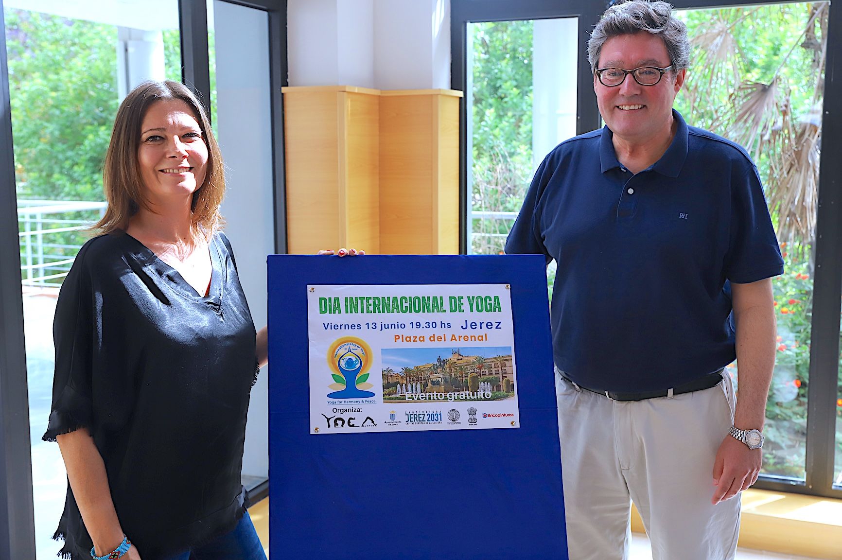 El delegado y la organización junto al cartel del Día Internacional del Yoga.