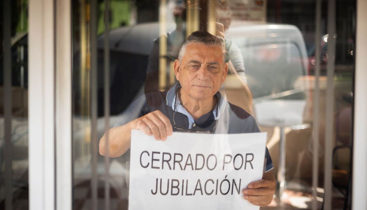 José Manuel Gómez, colocando el cartel en el escaparate.