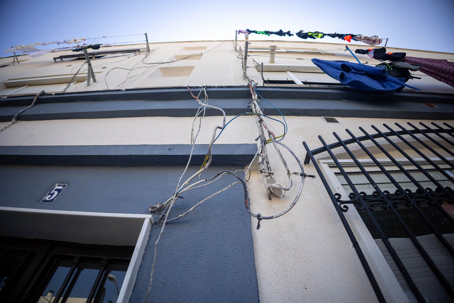 Cableado colgando por una fachada en la barriada de La Asunción de Jerez.