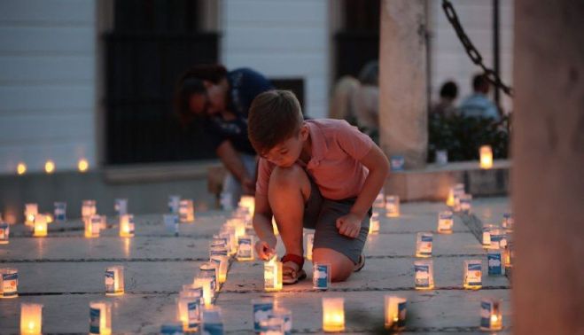 Un pequeño coloca una vela.