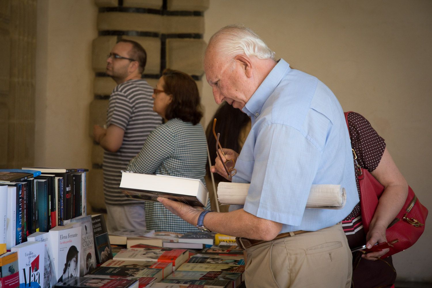 Un hombre consulta un ejemplar en una feria del libro andaluza, como la de Trebujena que ofrece bonos de descuento para gastar en las librerías.