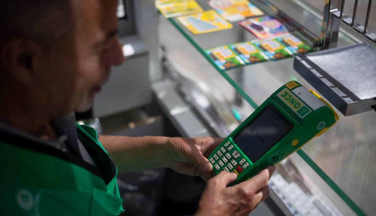 El cuponero manejando el terminal para comprobar premios. 