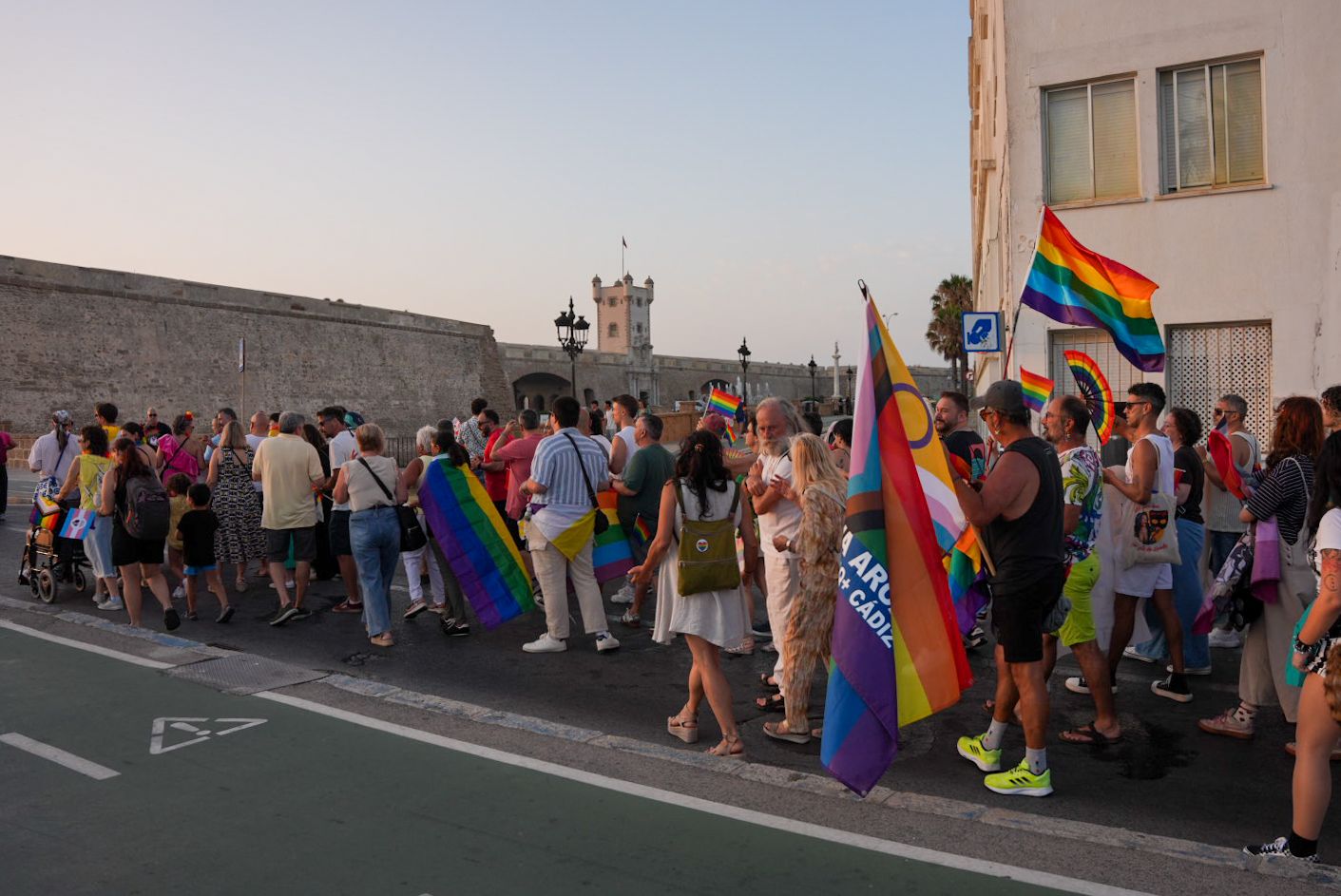 Manifestantes luciendo la bandera arco iris.