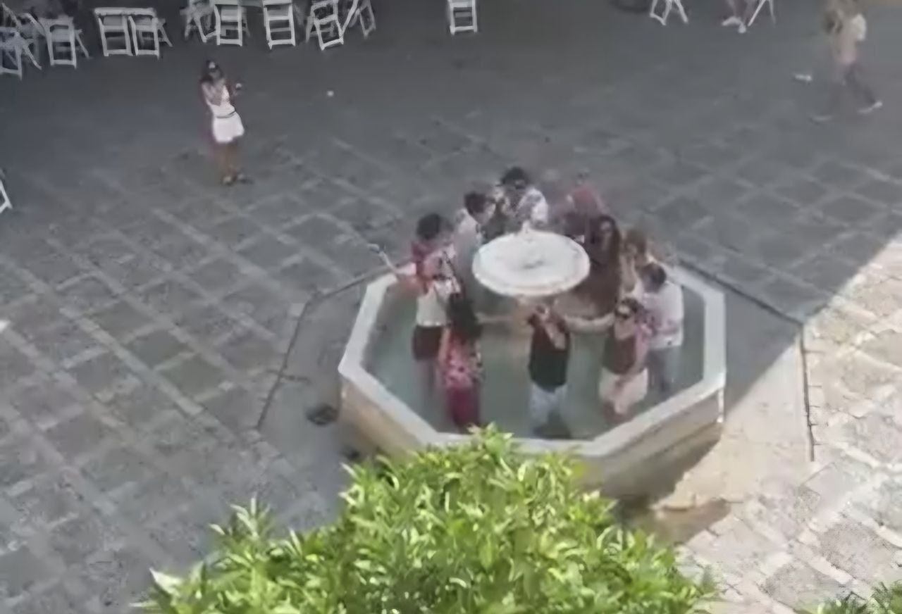 Conga de turistas en una fuente de Sevilla.