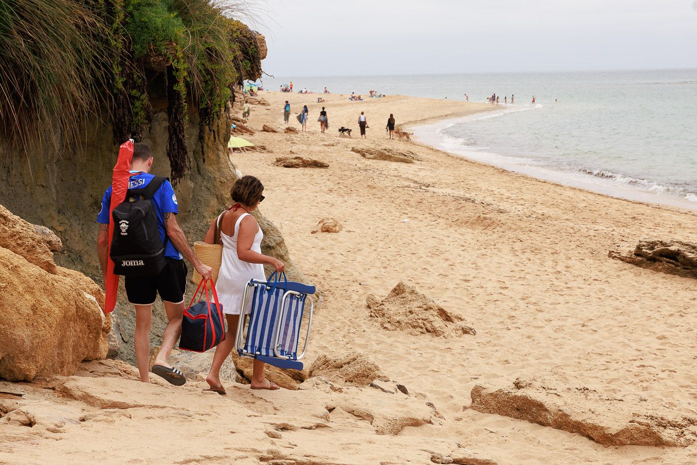 Personas llegando a la playa en la provincia de Cádiz, en Los Caños, una de las que se resguarda mejor del viento.