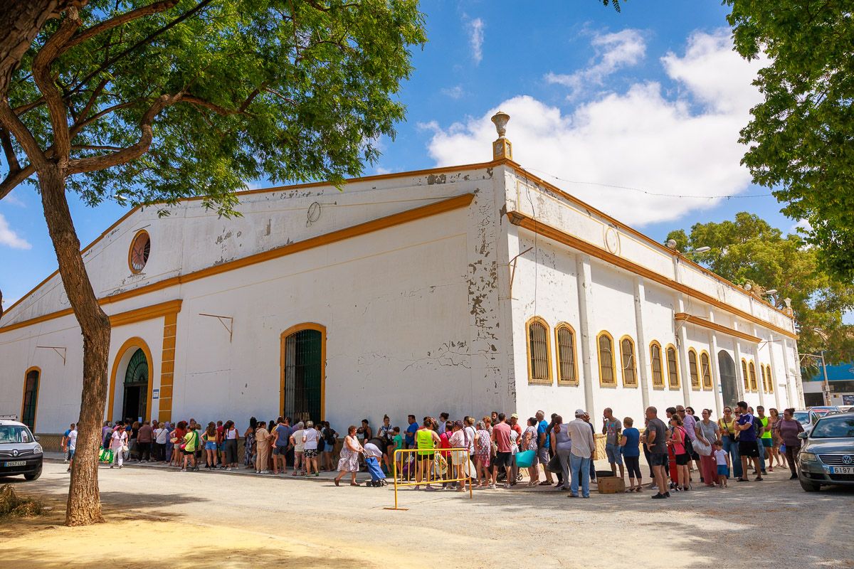 Lebrija se moviliza: vecinos acuden a la caseta municipal para recoger su parte.