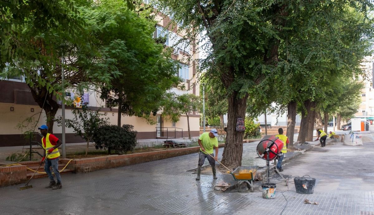 Operarios trabajando en el acerado.