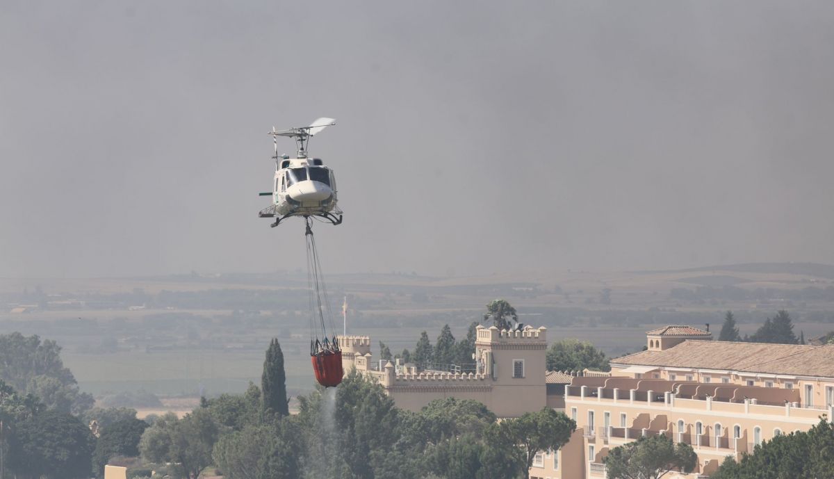 El helicóptero semipesado del Infoca recogiendo agua de la laguna del campo de golf de Montecastillo, este domingo en Jerez.