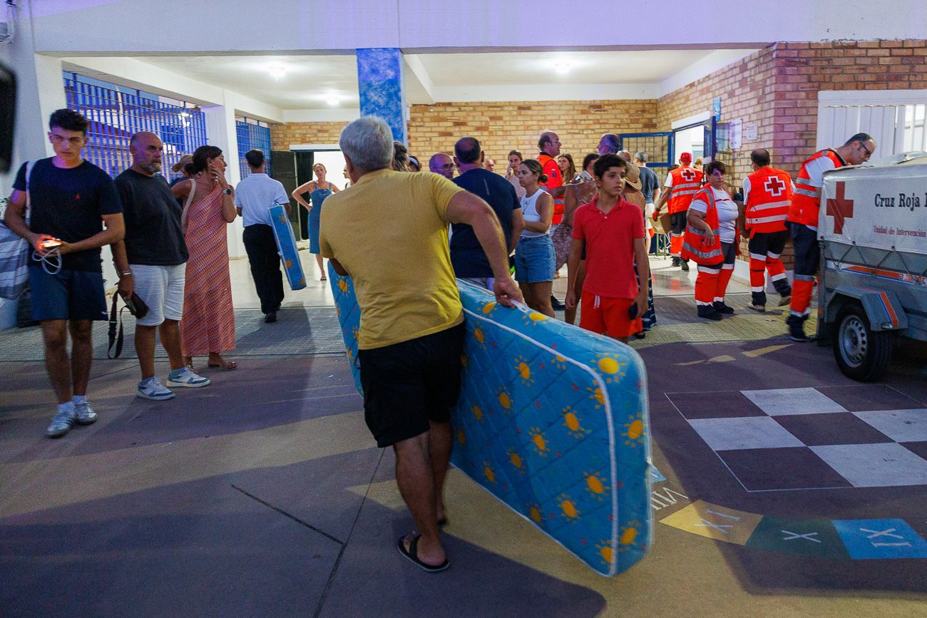 Un vecino carga un colchón para pasar la noche en el CEIP Miguel de Cervantes de Zahara 