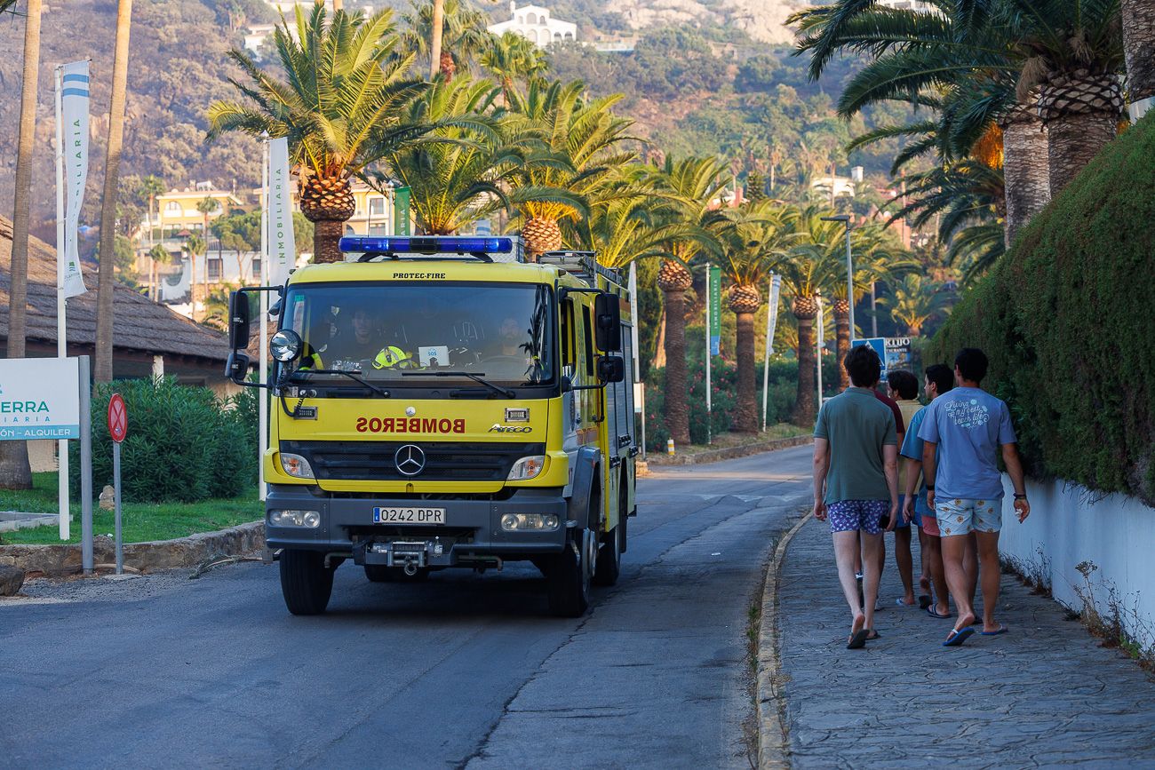 Un camión de bomberos pasa al lado de un grupo de vecinos