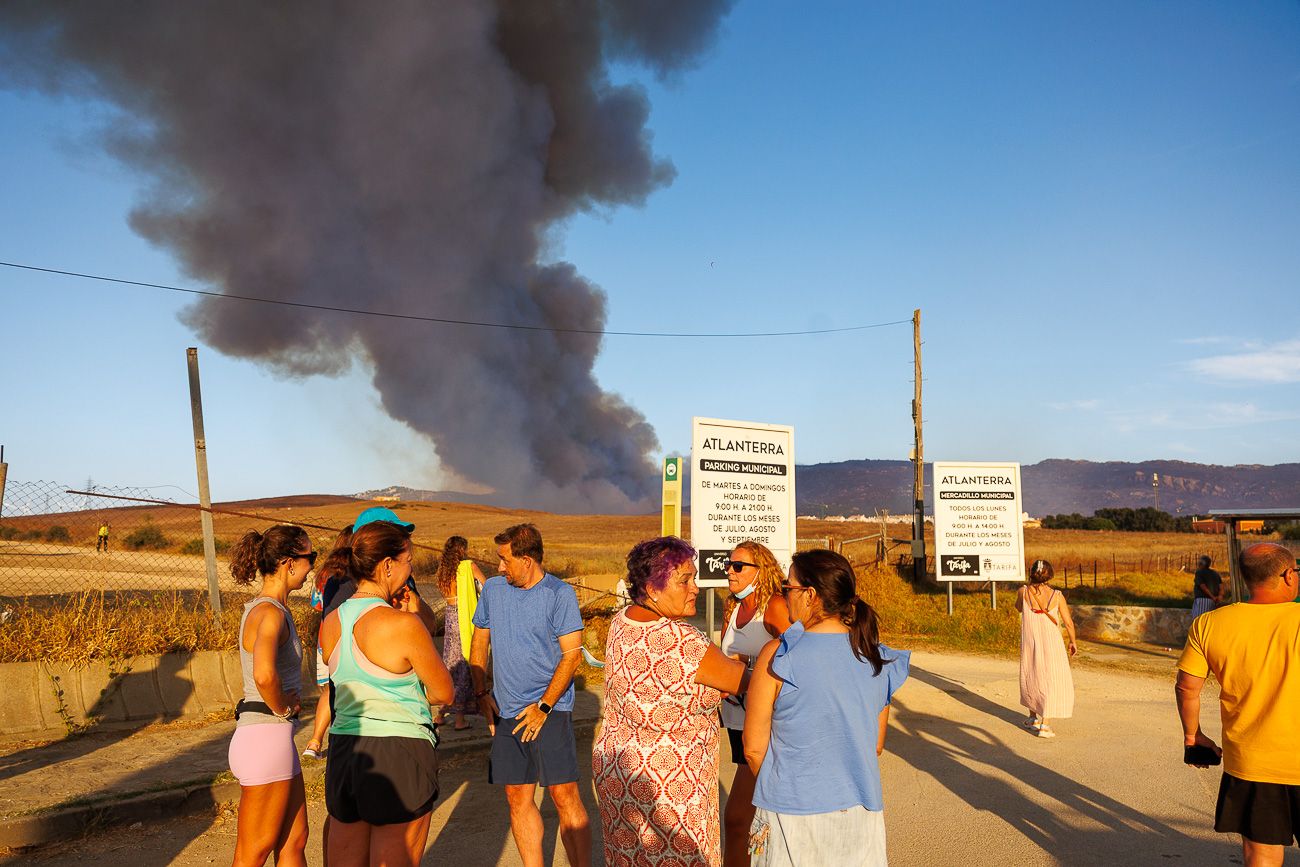 Vecinos de Atlanterra observan desde la distancia la columna de humo que cubre la costa