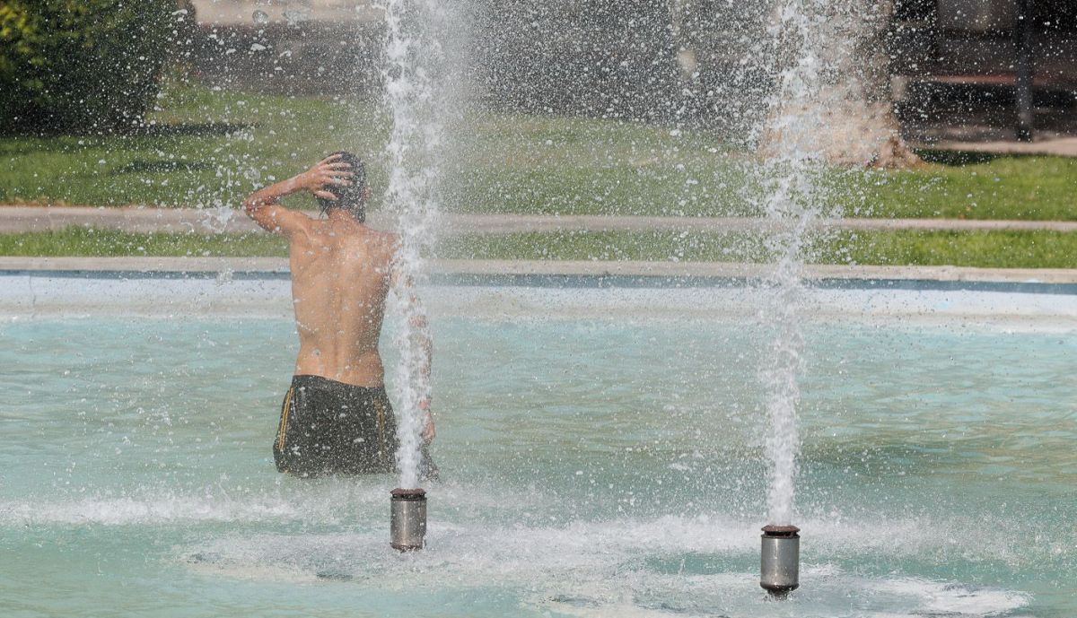 Un joven, refrescándose en una fuente del centro de Jerez.