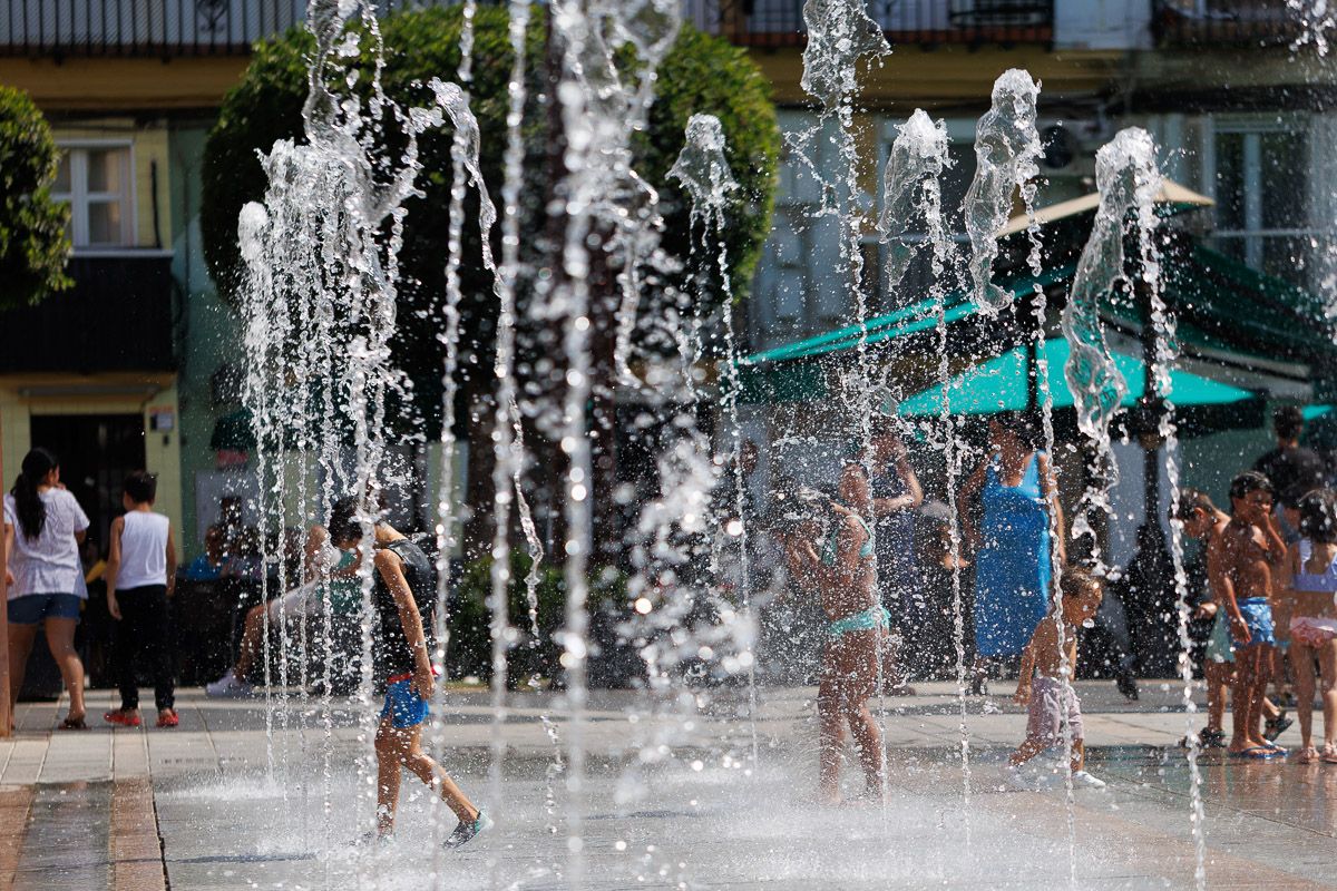 Niños metidos en una fuente pública, para soportar la ola de calor.