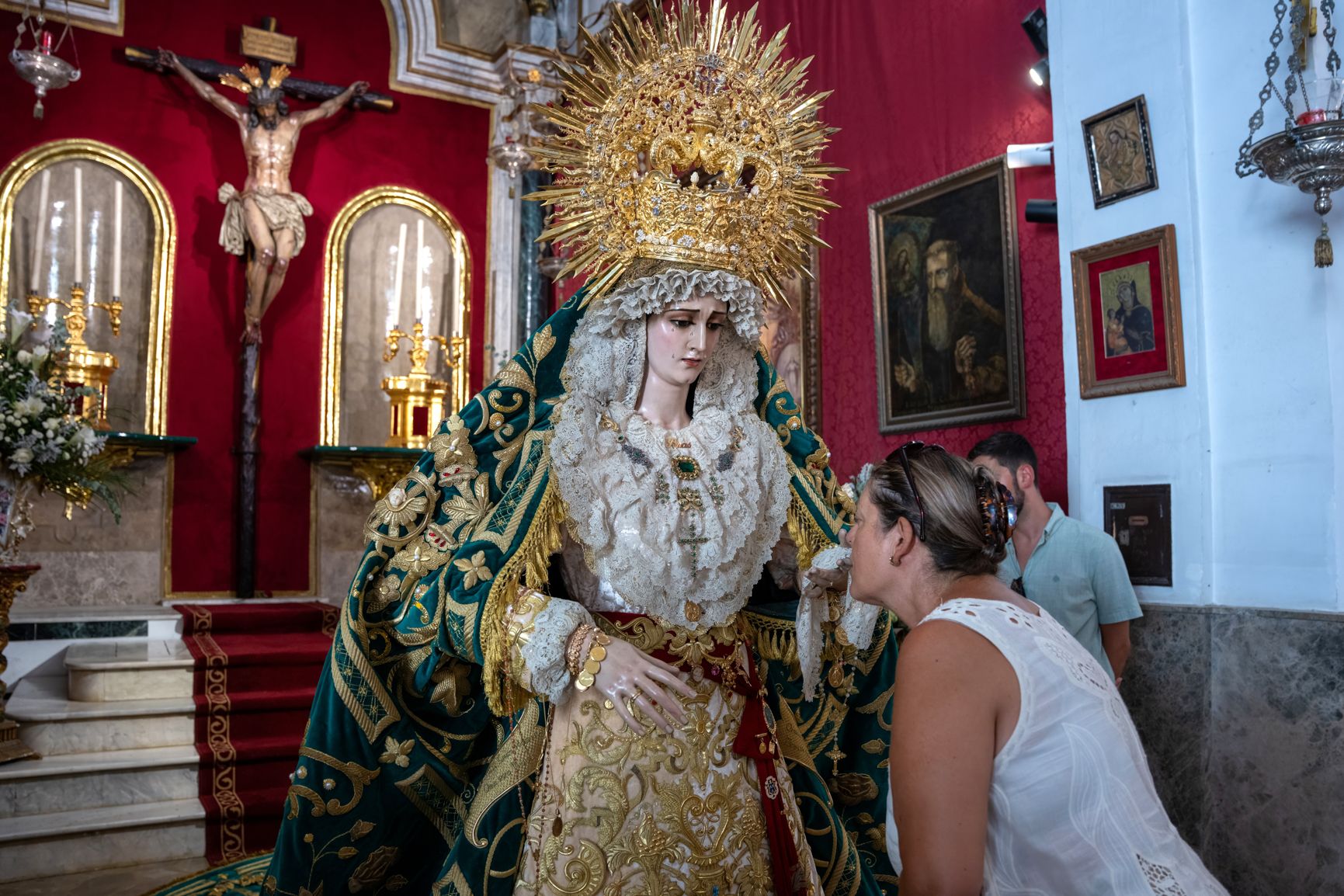 Una mujer besa la mano de la Virgen de Las Penas.