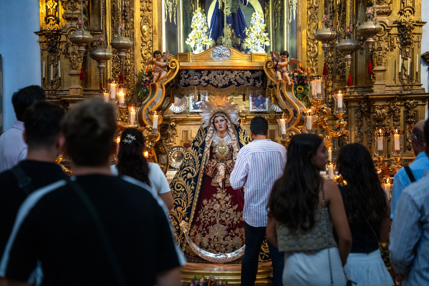 Un grupo de devotos, esperan para poder besar a la Virgen.