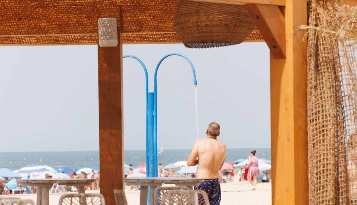 Un hombre se ducha en una playa de Rota, este lunes, día final de la ola de calor.