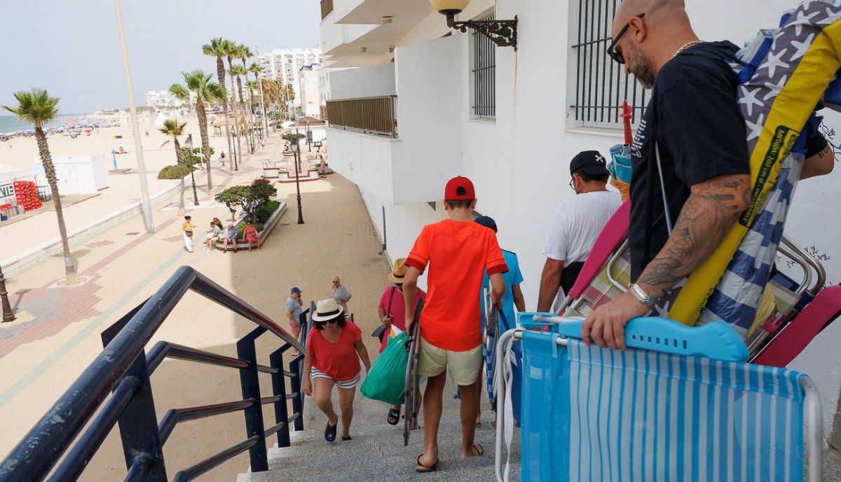 Personas llegando a la playa, en Rota.