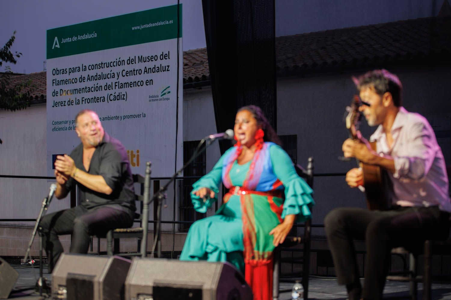 Cartel de la obra por el museo del flamenco detrás de los artistas.