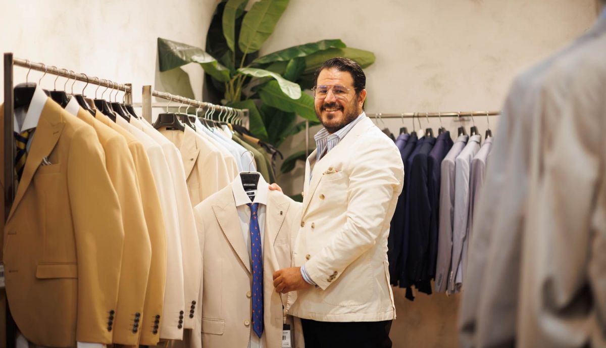 Juan Manuel rodeado de chaquetas y guayaberas.