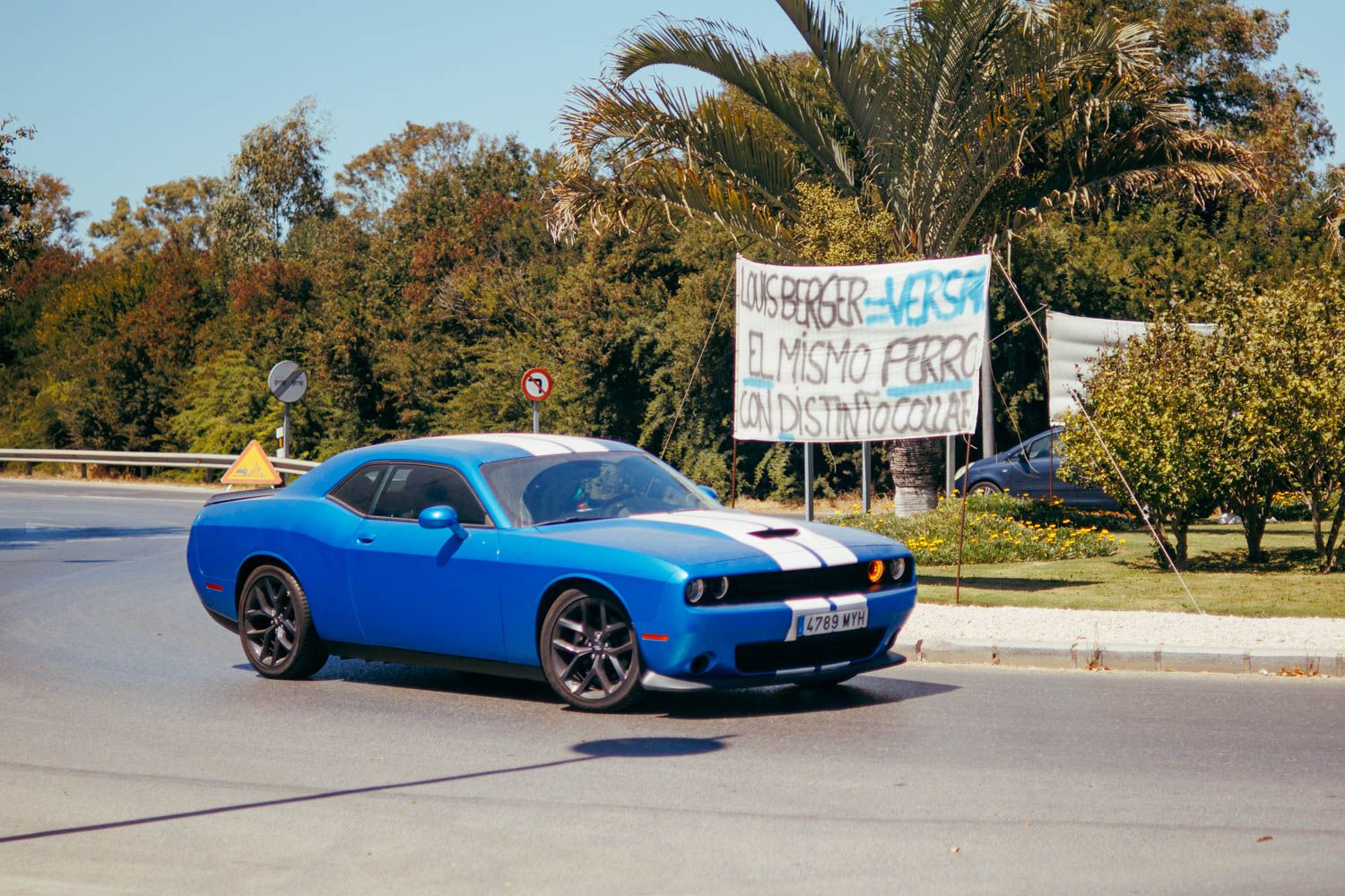 Un coche clásico americano frente a las pancartas a la entrada de la base de Rota.