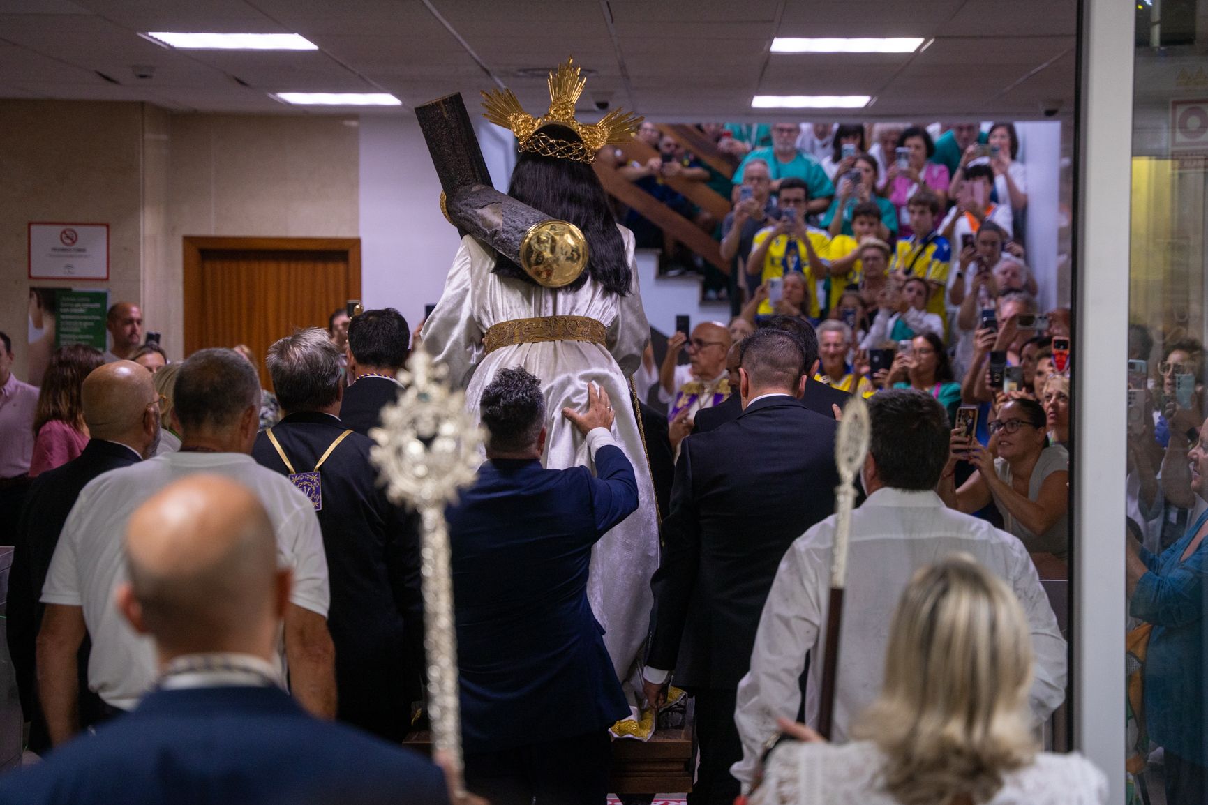 Al fondo medicos, familiares y enfermo a la espera de rezar al Nazareno 