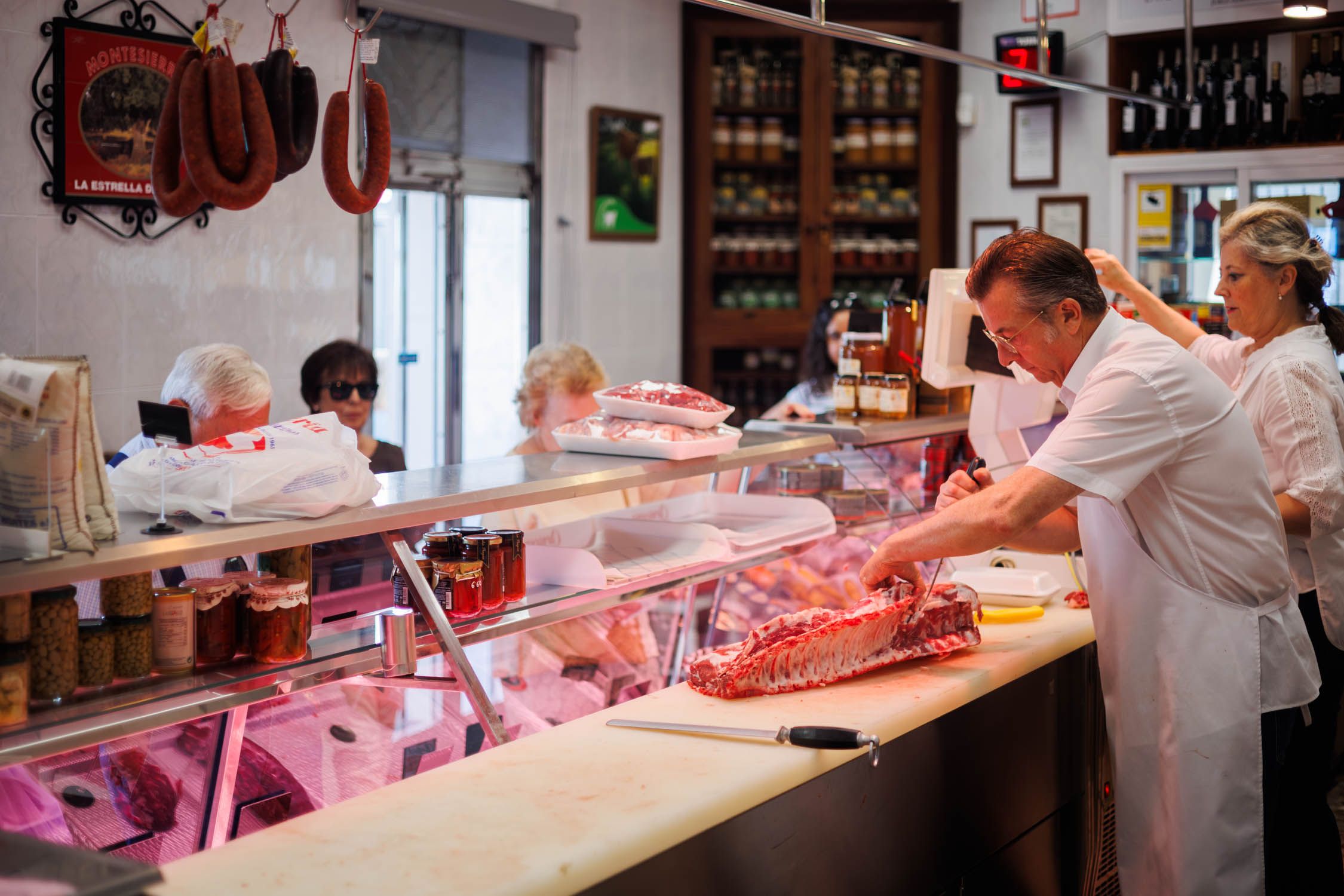 Un carnicero trabajando una pieza de carne.