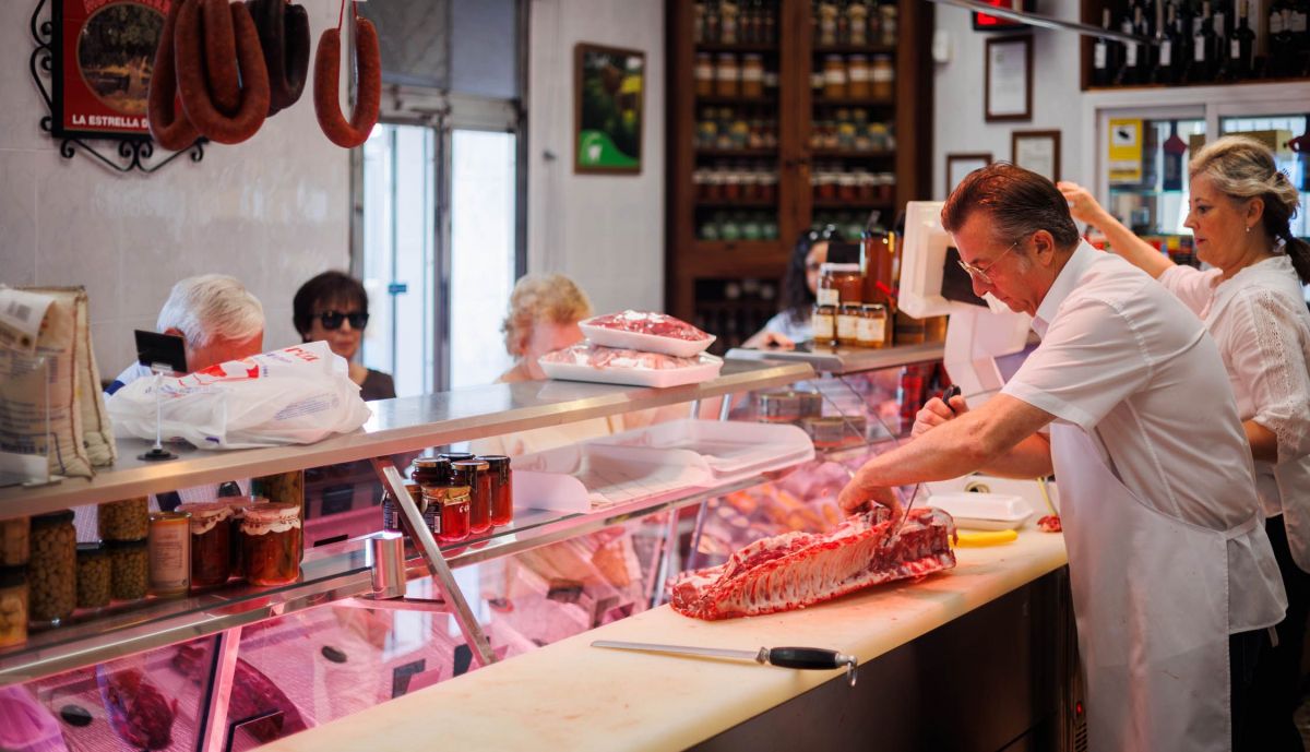 Un carnicero trabajando una pieza de carne.