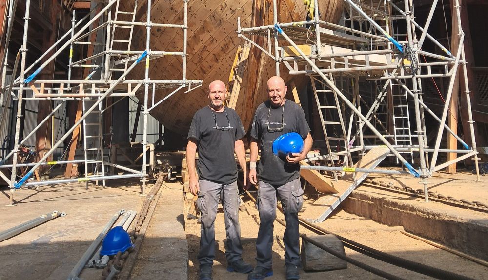 Antonio y Pedro junto al barco que están construyendo.