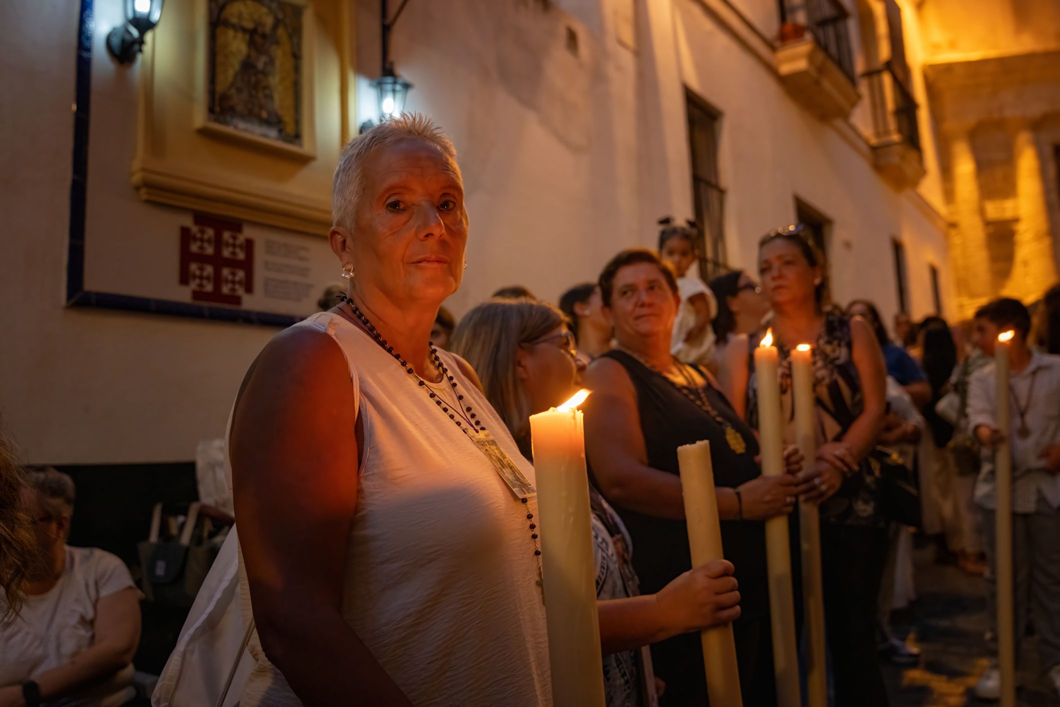 Hermanas del Nazareno con cera encendida acompañando a Jesús.