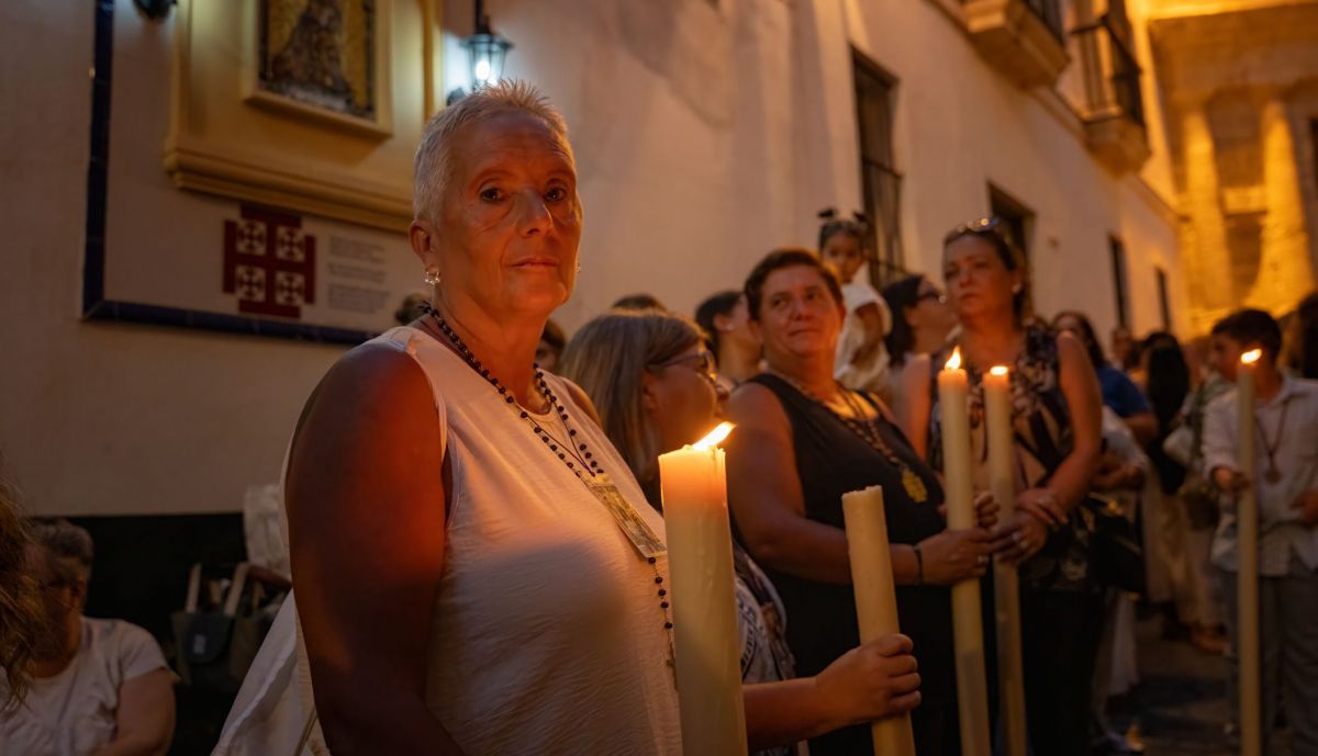 Hermanas del Nazareno con cera encendida acompañando a Jesús.