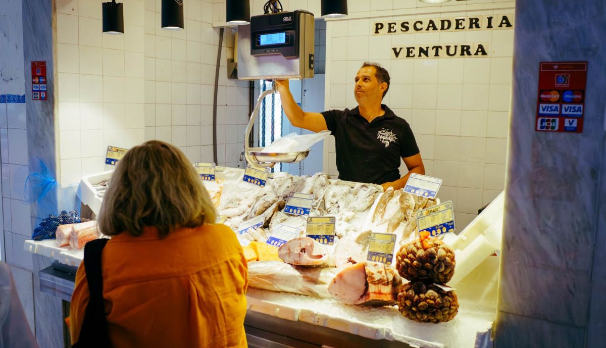 Quique atiende a una clienta en la plaza de El Puerto.