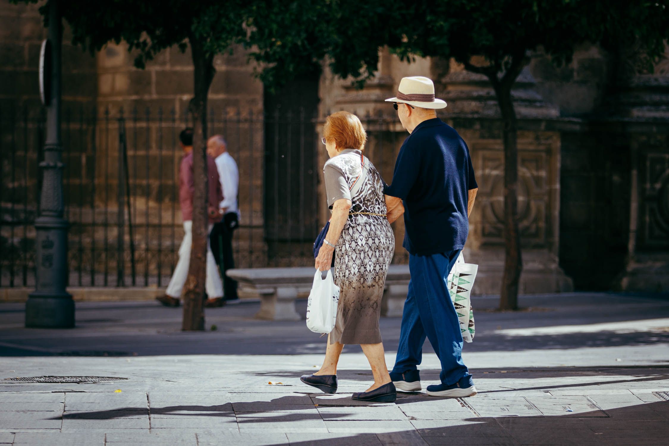 Dos personas mayores paseando por la calle. 