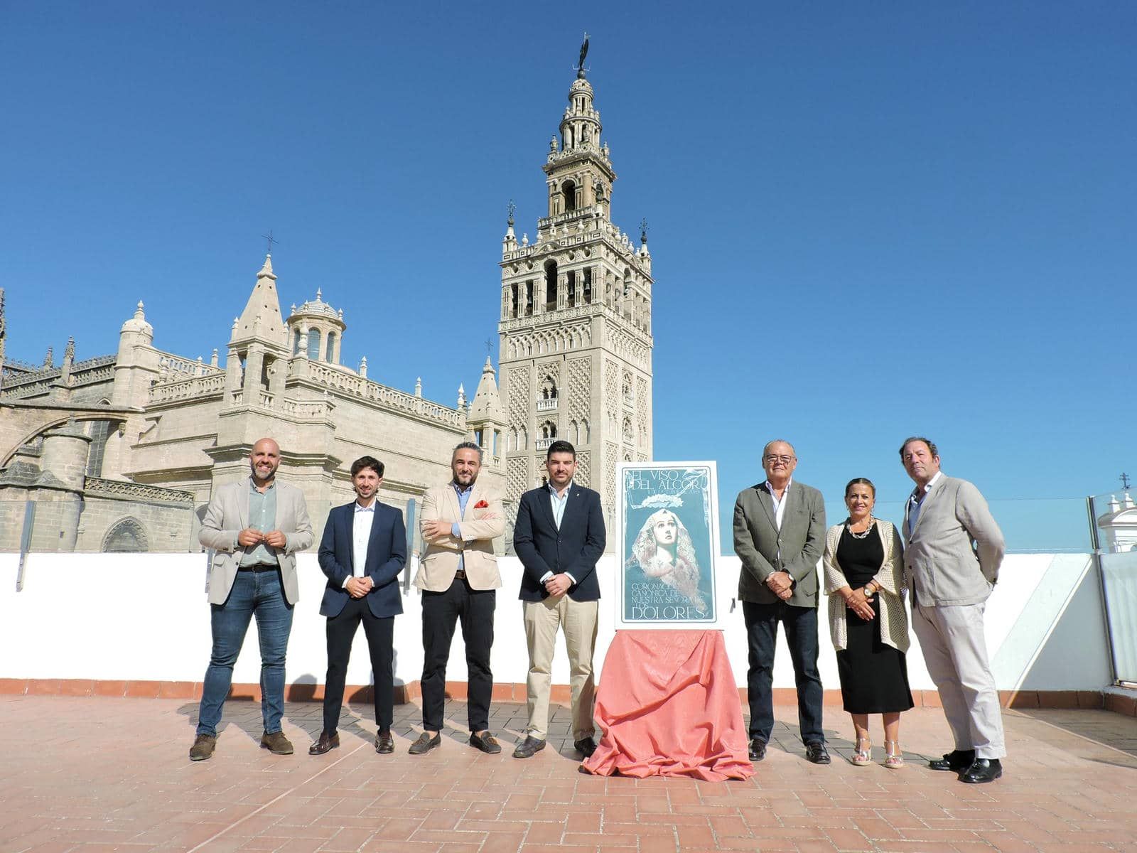 Presentación del cartel de la coronación canónica con la Catedral y la Giralda de Sevilla como fondo.  